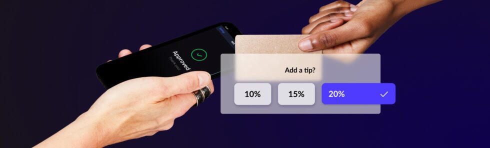 A credit card held near a mobile phone that says ‘Approved’ with a tip-selection prompt
